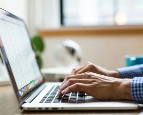 person typing on silver Macbook